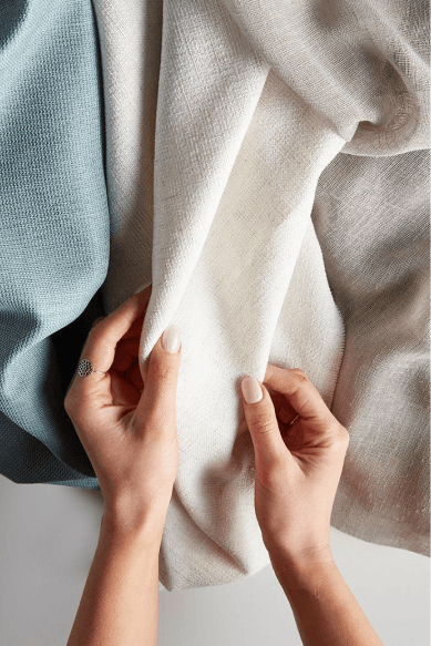 Hands holding woven fabric — community impact